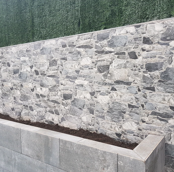 Murete de obra delante de una pared de piedra