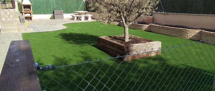 Jardinera de madera con árbol sobre césped artificial