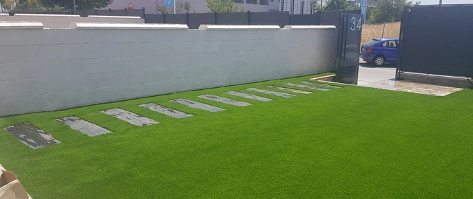 Pasos de piedra sobre césped junto a una terraza