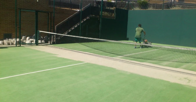 Vista de una pista de pádel con su red y césped verde