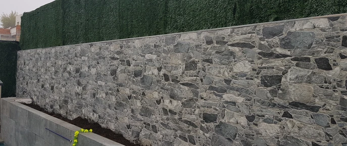 Murete de obra delante de una pared de piedra